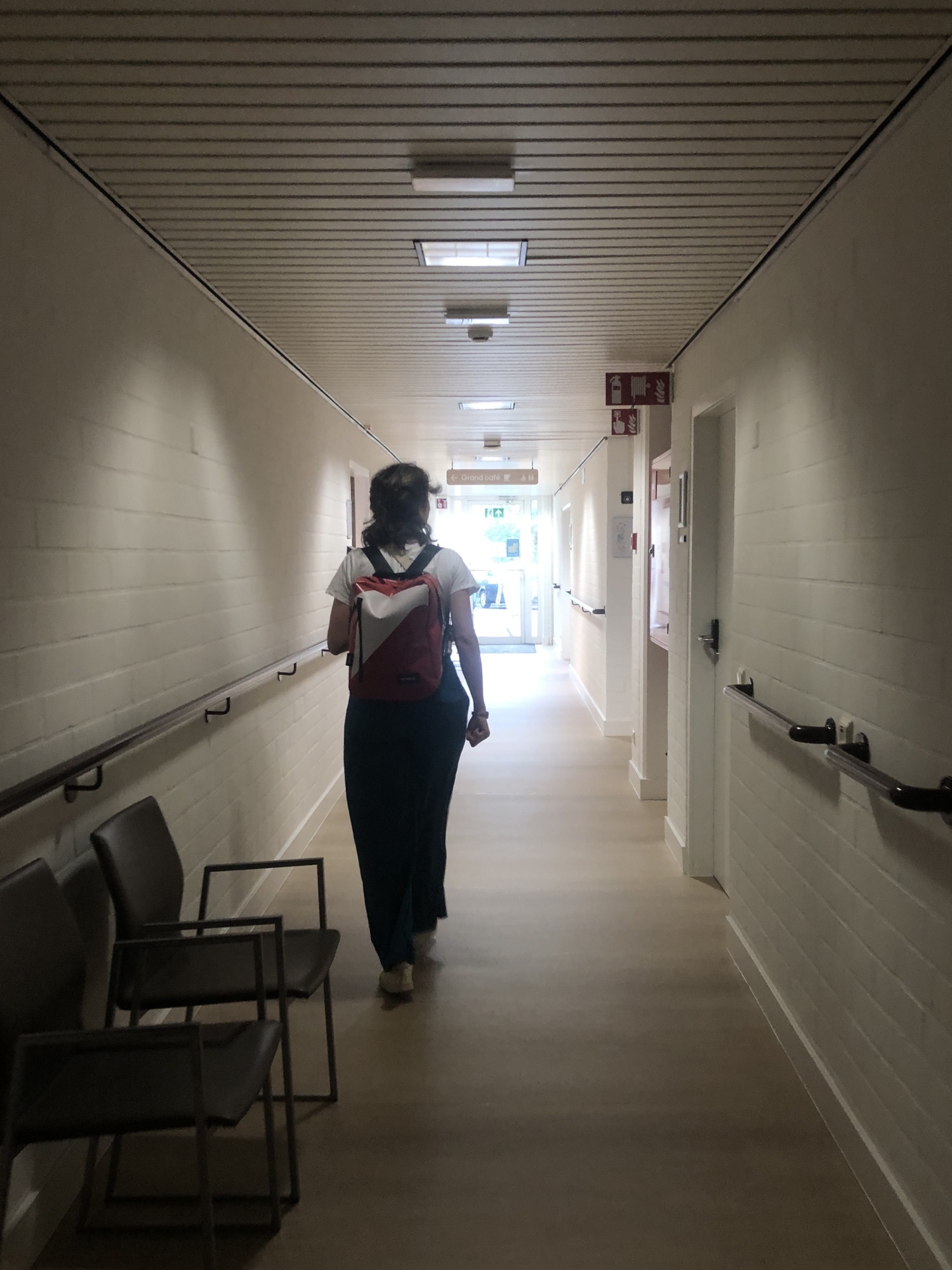 <p><em>Teaching artist</em> Sari Veroustraete wandelt door de gangen op weg naar de theatersessie in OLV Van Troost, 2025, foto door Lies Vandeburie.</p>