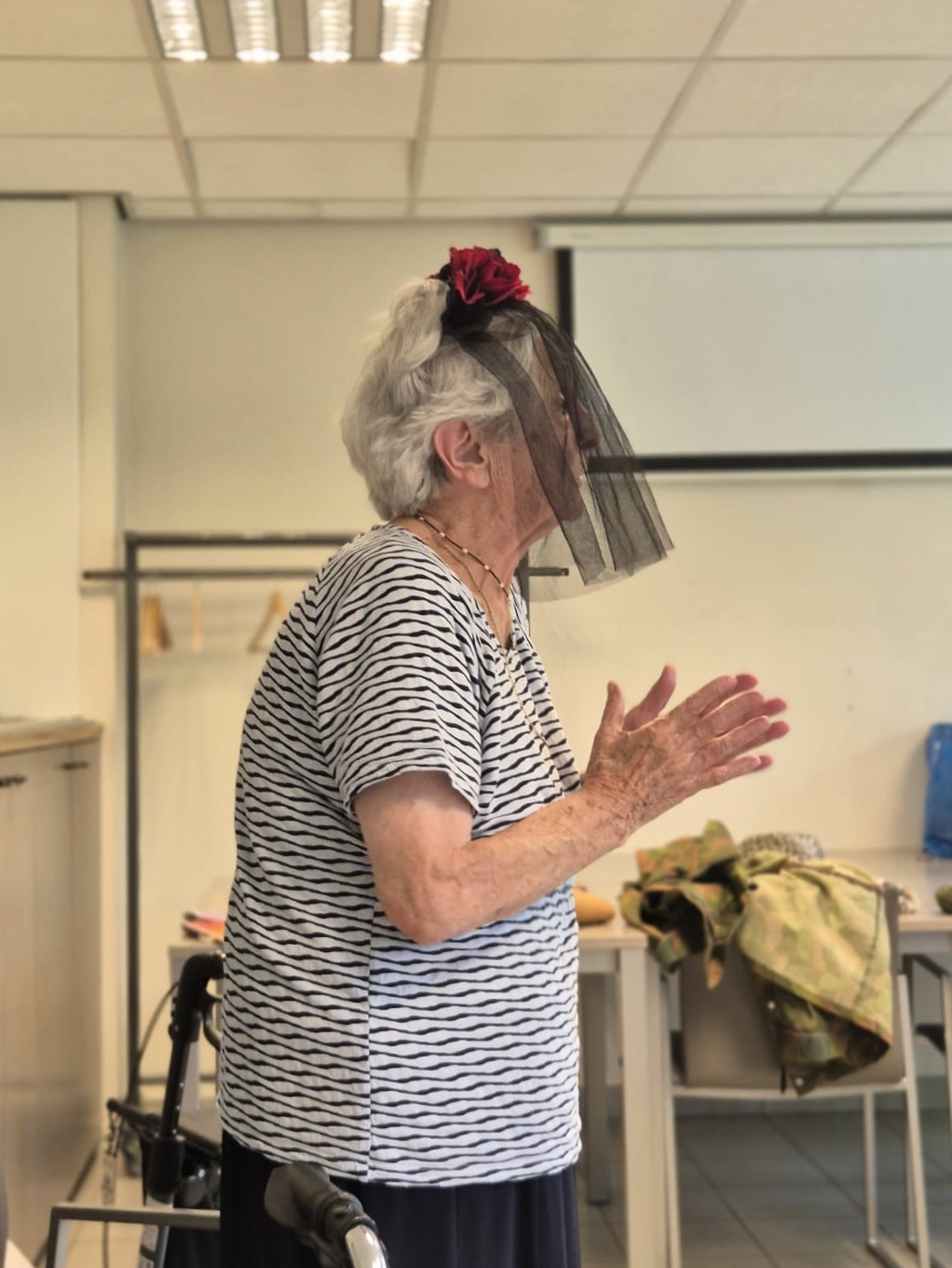 <p>Een bewoonster speelt een ‘emotionele weduwe’ tijdens een theatersessie rond personages creëren aan de hand van attributen in woonzorgcentrum OLV van Troost, 2025, foto door Kelly Van Elewijck.</p>